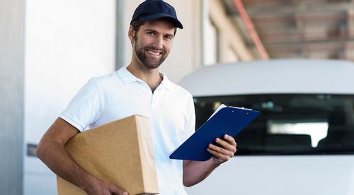 Mover holding a box and a clipboard with the written moving quote