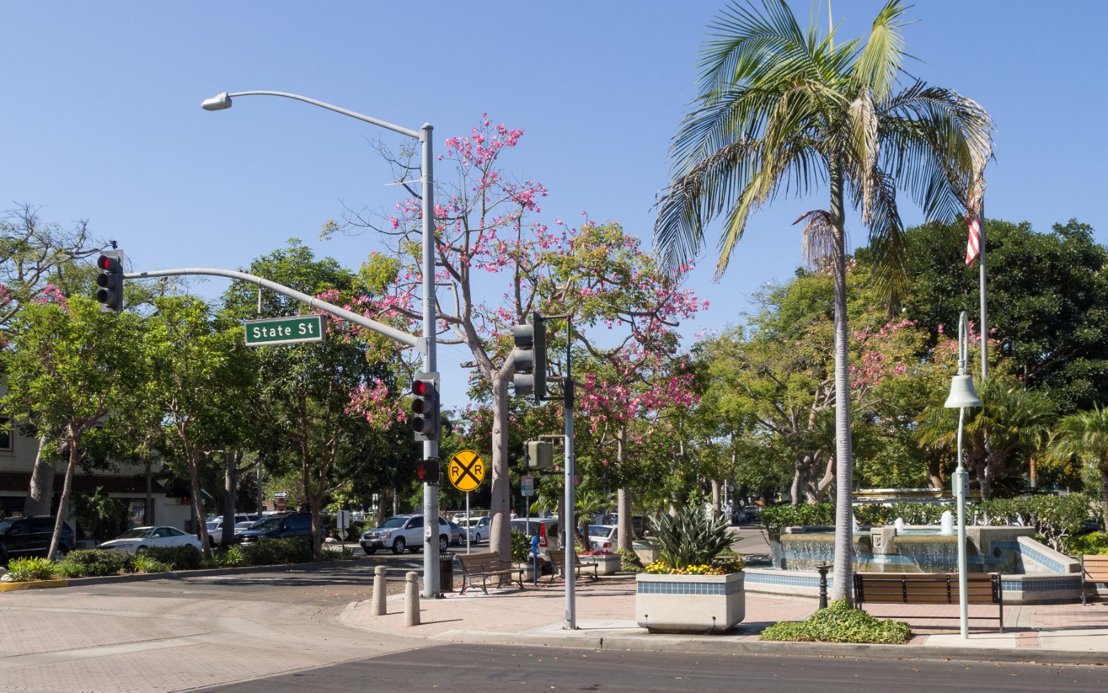 Street corner in Carlsbad Village, California, with parked cars and palm trees where California Movers USA confirms the legal truck position