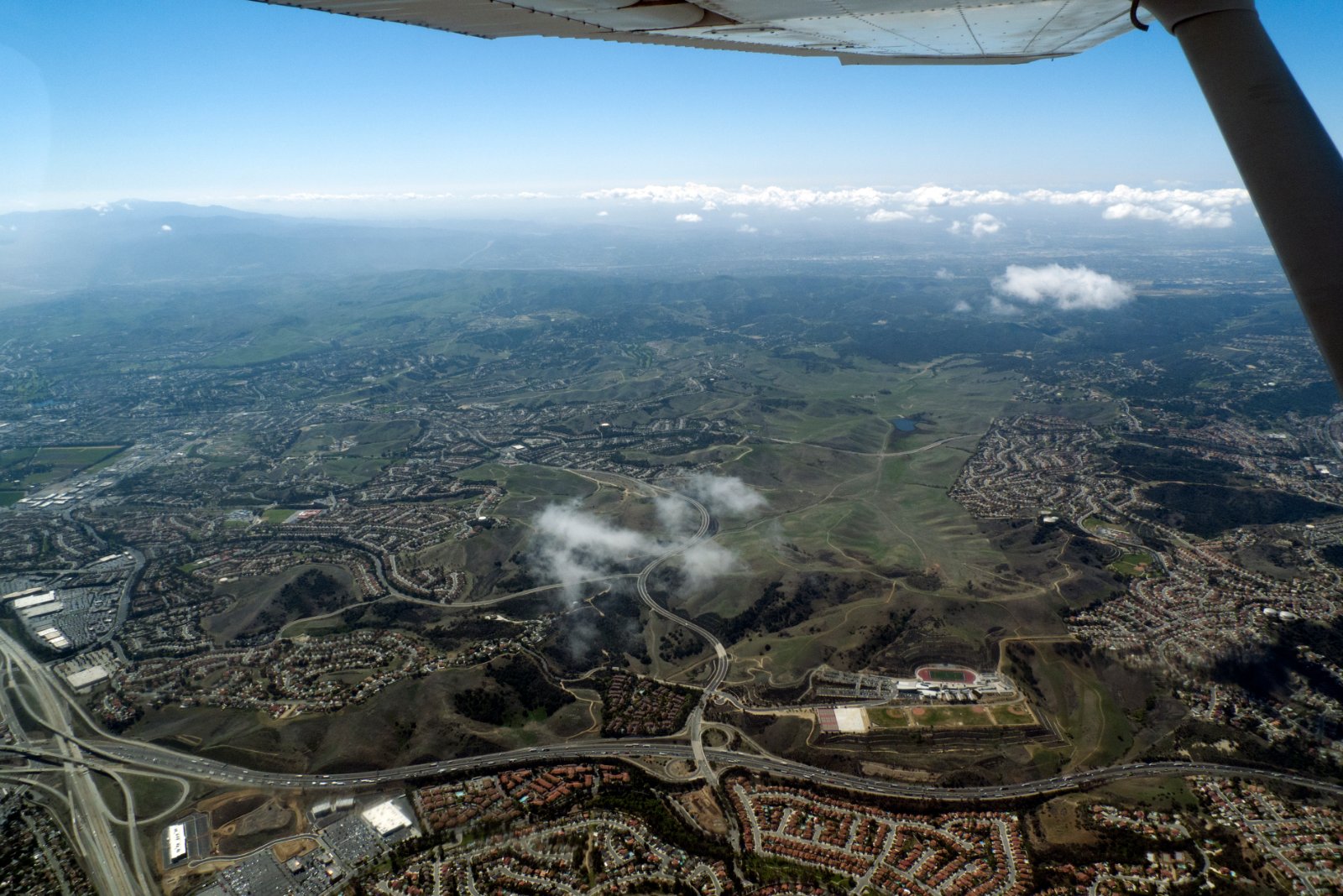 Aerial view of hillside residential neighborhoods and curving streets in Chino Hills, California, where California Movers USA checks road grade and truck clearance before dispatch