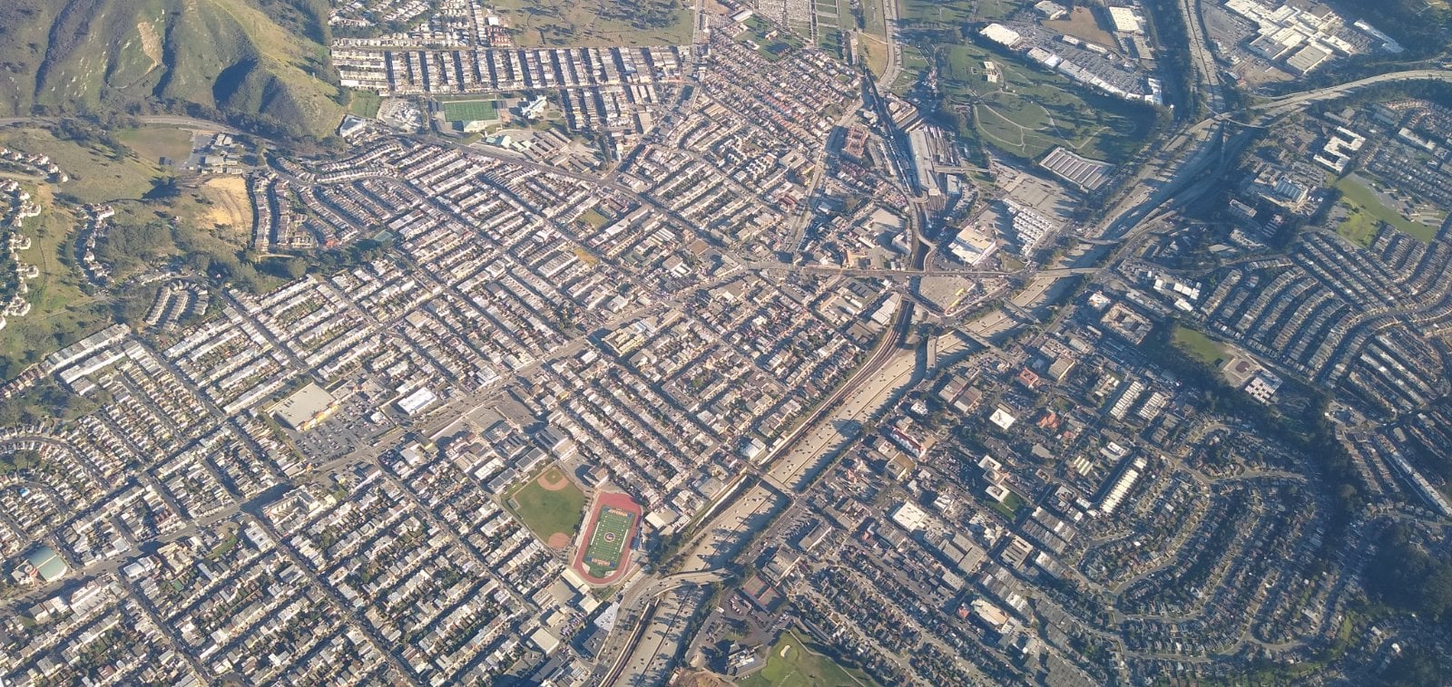Aerial view of dense hillside residential streets in Daly City, California, where California Movers USA checks grade and the legal truck position before a move