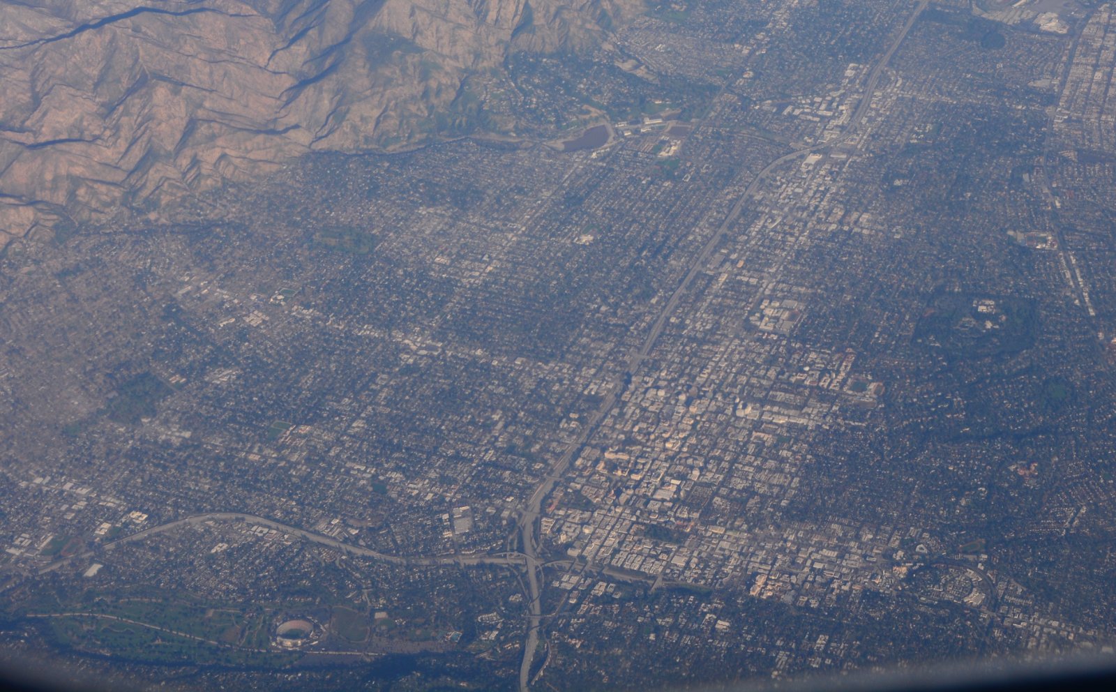 Aerial view across Los Angeles County toward the San Gabriel foothills, showing the mix of dense grid streets and hillside neighborhoods Halo plans for