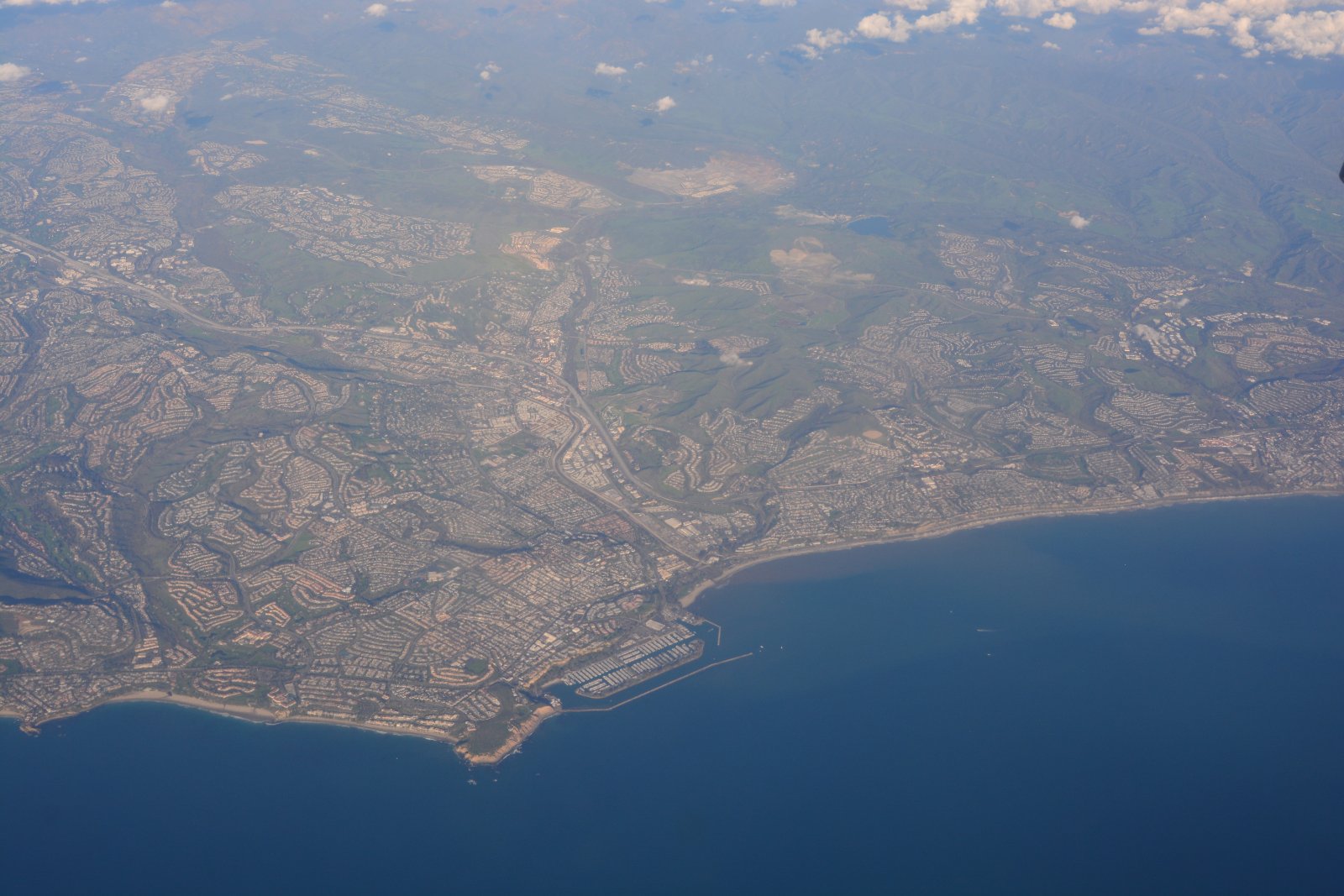 Aerial view of the Orange County coastline and inland neighborhoods near Dana Point, California, where Halo California Movers plans coastal and inland access separately