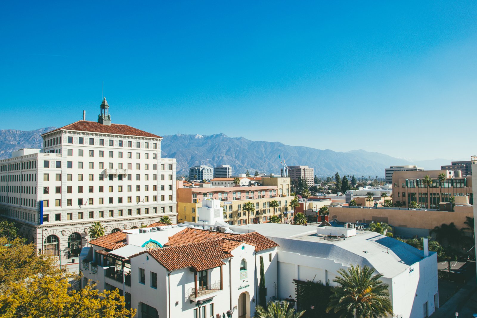 Mid-rise buildings and tree-lined streets of Playhouse Village in Pasadena, California, seen from above
