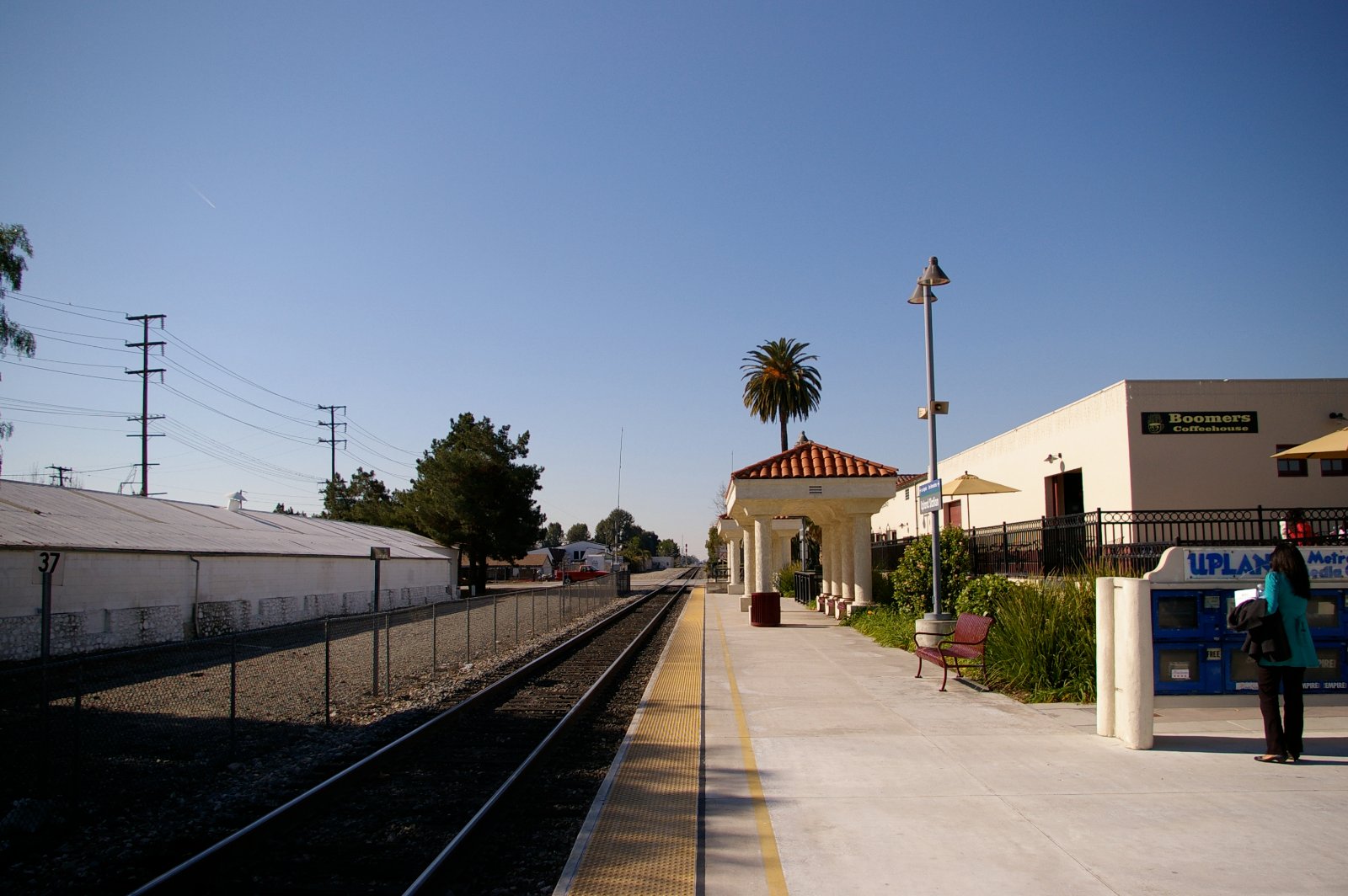 The Metrolink station platform and depot building in Upland, California, with the foothills behind